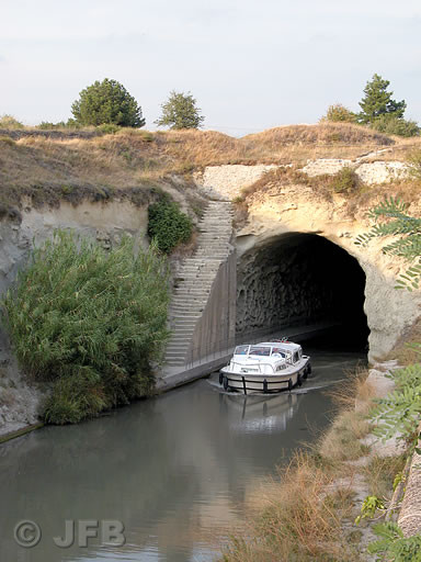 Prise de vue verticale : Un bateau sort du tunnel du Malpas et se dirige vers l'Ouest.