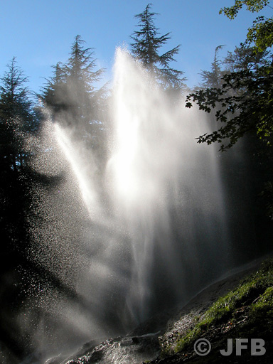 Contre jour sur la gerbe d'eau. Les rayons du soleil s'immiscent dans l'ensemble du jet d'eau