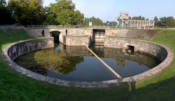 Vue d'ensemble de l'écluse des Lorrains, par une belle fin de
 journée en Septembre 2004. Beaucoup de verdure et un beau ciel bleu sur le bassin rond. On aperçoit à gauche, la porte en direction 
 du canal latéral à la loire, et à droite, celle qui mène directement vers l'Allier