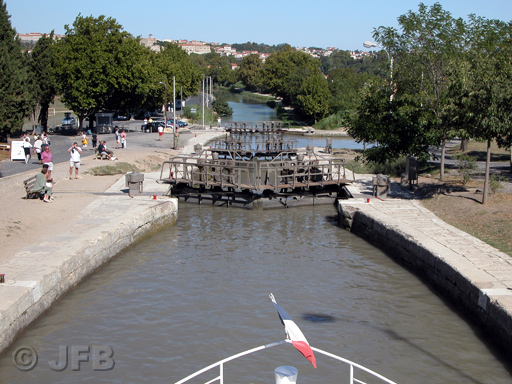 La pointe d'une péniche. Un drapeau Français, et plus loin, la belle ville de Béziers. Nous sommes dans la descente de l'écluse octuple de Fonsérannes...