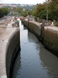 Vue d'aval et en diagonale sur les écluses toutes vannes ouvertes. C'est
    le soir et l'escalier d'eau ne fonctionne pas.