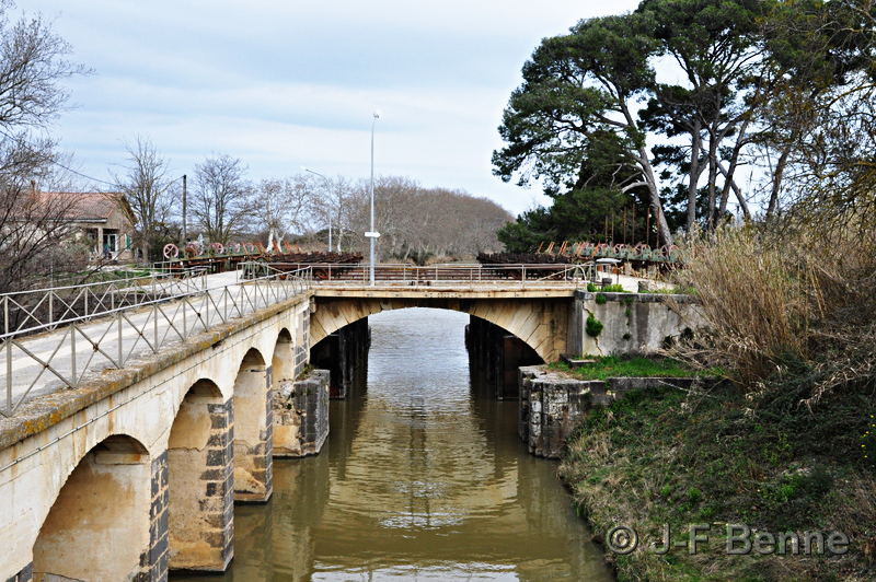 Vue de la deuxième partie des ouvrages du Libron, et au premier plan, le bassin central. à gauche, le pont qui permet le passage poue les éclusiers d'un ouvrage à l'autre. En perspective, le Canal du Midi continue vers Agde et à droite, un bosquet de pins.