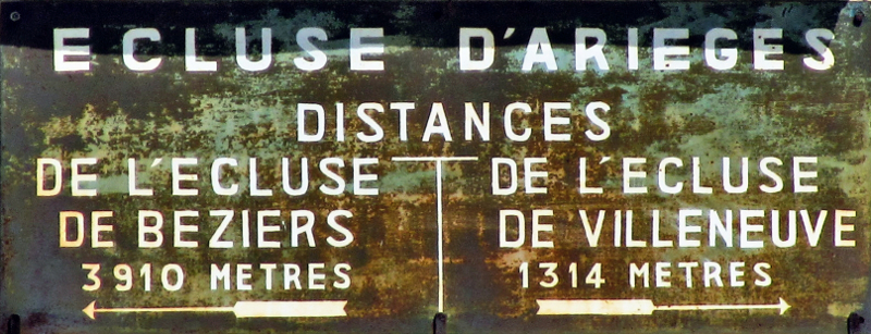 Panneau indicateur de l'écluse d'Arieges. Distance jusqu'à l'écluse dde Béziers : 3910 mètres, 
et jusqu'à l'écluse de Villeneuve : 1314 mètres