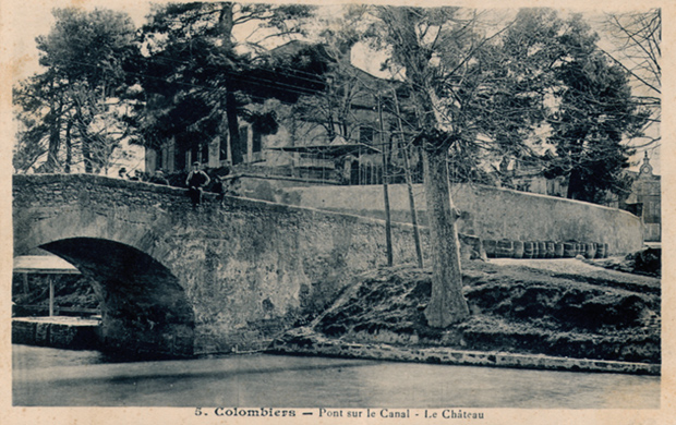 Vue du Canal &agrave; Colombiers, dans l'H&eacute;rault. Gros plan sur le pont et quelques barriques sur la berge