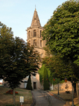 Vue en contre-plongée de l'église d'Avignonet-Lauragais par un beau soir d'été. Le soleil donne à l'ensemble une teinte orangée.