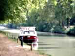 Petite péniche rouge et blanche amarrée non loin du port, en regardant vers Carcassonne