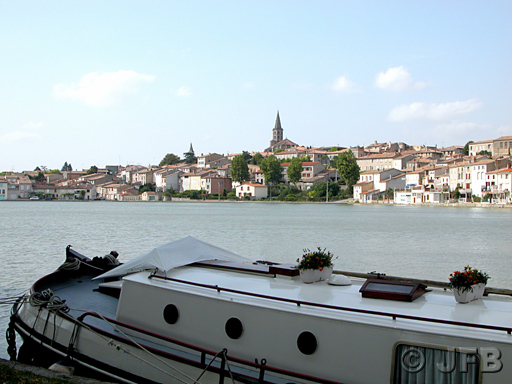 Au premier plan, une péniche amarrée. Vue du Grand Bassin et de la ville de Castelnaudary - L'église