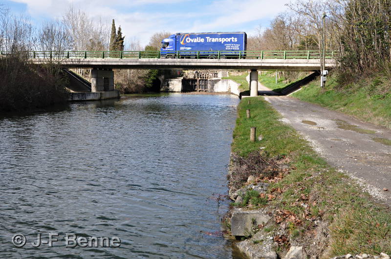 Un camion bleu passe sur le pont en aval de l'écluse de Gay