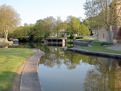 Vue du bassin ovo?de de l'écluse. à droite en arrière plan : le vieux lavoir, et à gauche, une péniche noire et blanche