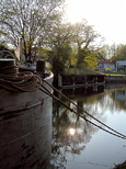 Contre-jour sur une vieille péniche, le lavoir en fond, le soleil se reflete dans l'eau...