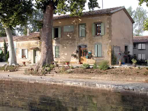 La maison de l'écluse, ornée de deux platanes plusieurs fois centenaires. Vue prise depuis l'autre rive du canal