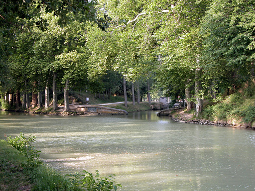 Arrivée de la Rigole de la plaine dans le Canal du Midi. Vue prise face à la Rigole. Les eaux sont très grises