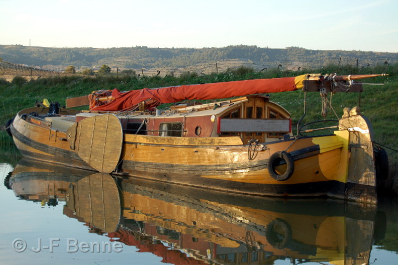 Canal du Midi : Dans les couleurs du soir, une péniche joliment décorée est amarrée à Argeliers 