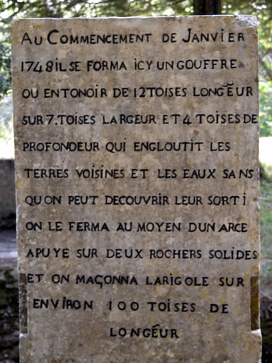 Stèle commémorative sur laquelle est écrit : Au commencement de janvier 1748, il se forma ici un gouffre ou entonnoir de 12 toises de longueur sur 7 toises de largeur et 4 toises de profondeur qui engloutit les terres voisines et les eaux sans qu'on put découvrir leur sortie. On le ferma au moyen d'un Arce appuyé sur deux rochers solides et on maçonna la rigole sur environ 100 toises de longueur.