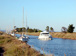 Canal du Midi : près de l'embouchure sur l'étang de Thau, un bateau blanc photographié de face. Il vient de l'étang et se dirige vers Agde