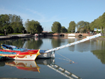 Le bassin de l'embouchure. On distingue au loin les trois ponts jumeaux et le bas relief, au premier plan, deux barques de joutes très colorées