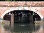 Prise de vue au télé-objectif, sous l'un des ponts jumeaux dont le parapet est éclairé par le soleil, le Canal de Brienne continue dans l'ombre...