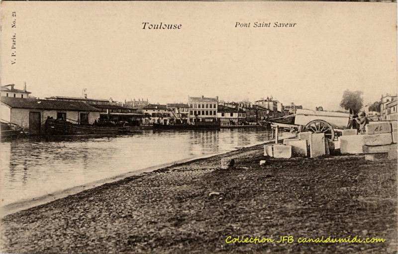 Carte postale ancienne légendée : Toulouse, port Saint Sauveur. Très peu d'activité le jour de cette prise de vue. On aperçoit le port dans toute sa largeur, quelques péniches, un peu rares, sur les bords. À gauche se trouve le bâtiment de la capitainerie qui est toujours là aujourd'hui, presque inchangé. À droite, dans les premiers plans, on voit un pin.